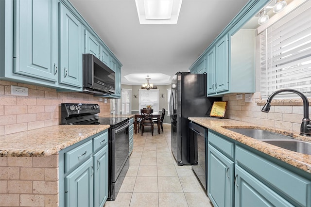kitchen with blue cabinets, tasteful backsplash, a sink, light tile patterned floors, and black appliances