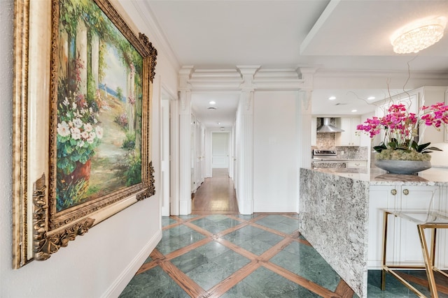corridor with baseboards, ornamental molding, decorative columns, and recessed lighting