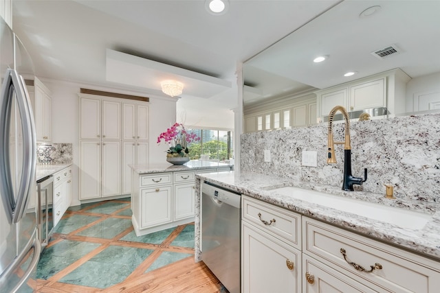 kitchen featuring backsplash, visible vents, appliances with stainless steel finishes, a sink, and recessed lighting
