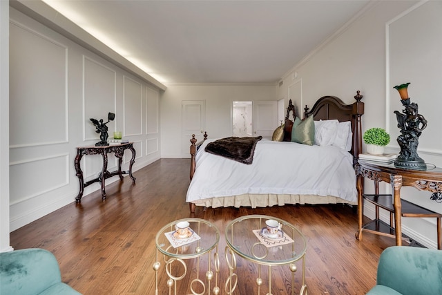 bedroom with ornamental molding and wood finished floors