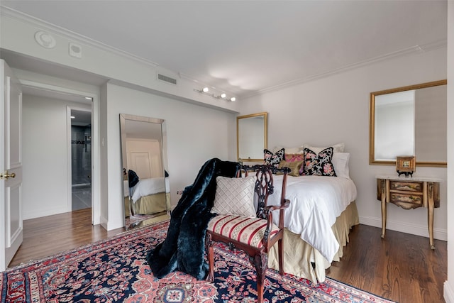 bedroom featuring crown molding, wood finished floors, and visible vents