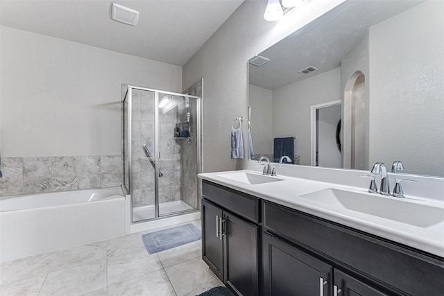 bathroom featuring visible vents, a shower stall, a sink, and a garden tub