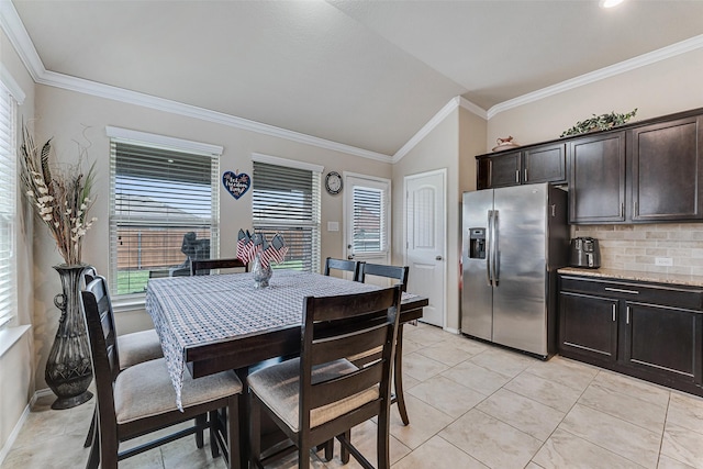 dining area with crown molding, baseboards, plenty of natural light, and lofted ceiling