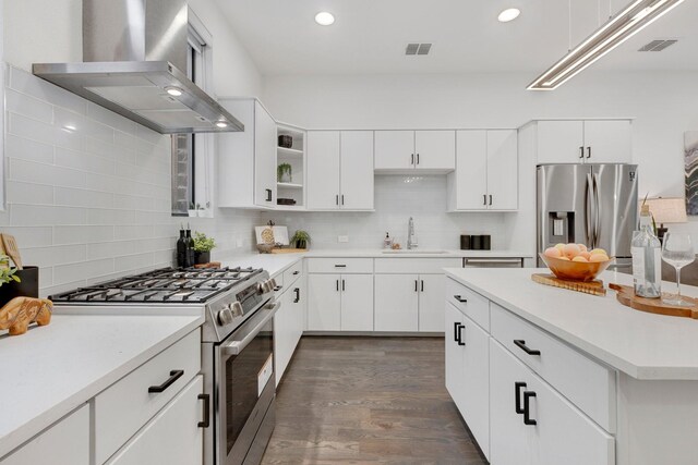 kitchen featuring a sink, tasteful backsplash, stainless steel appliances, and wall chimney exhaust hood