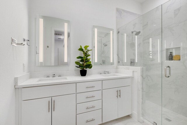 full bath featuring a sink, a marble finish shower, and double vanity