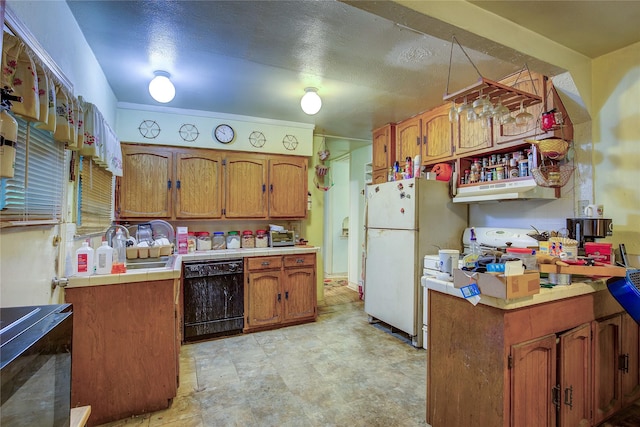 kitchen featuring black dishwasher, tile counters, brown cabinetry, and freestanding refrigerator