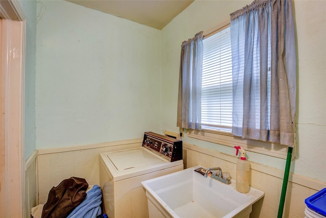 washroom featuring a sink, laundry area, washer / clothes dryer, and a wealth of natural light