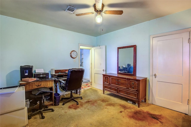 home office featuring carpet floors, ceiling fan, and visible vents