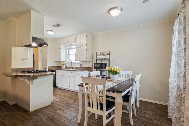 dining space with ornamental molding, baseboards, and wood finished floors