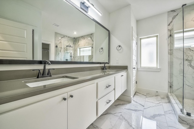 bathroom featuring a sink, a marble finish shower, double vanity, and marble finish floor