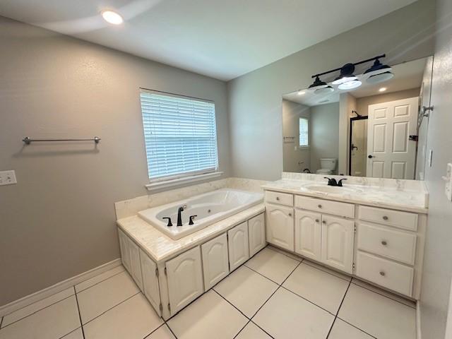 bathroom with a jetted tub, a stall shower, vanity, tile patterned floors, and toilet