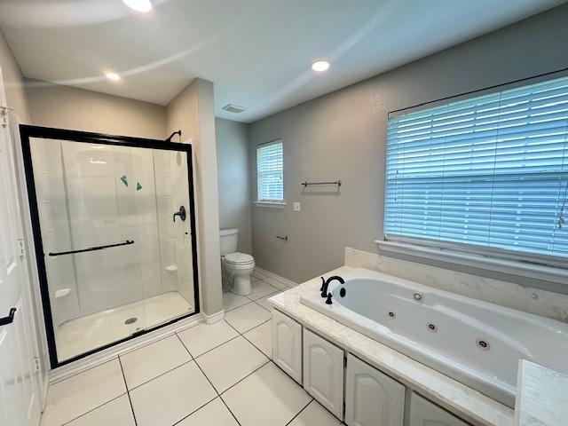 bathroom with toilet, tile patterned floors, a jetted tub, baseboards, and a stall shower