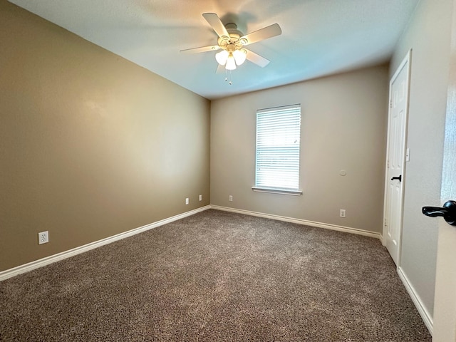 carpeted spare room with baseboards and a ceiling fan