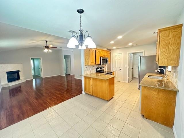 kitchen featuring a sink, stainless steel appliances, open floor plan, recessed lighting, and a peninsula
