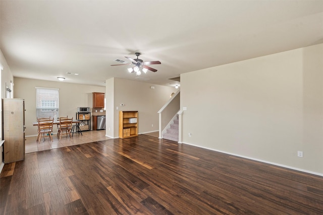 6728 Tierra Dr, Woodway, TX 76712 - unfurnished living room featuring dark wood-style flooring, stairs, a ceiling fan, baseboards, and visible vents