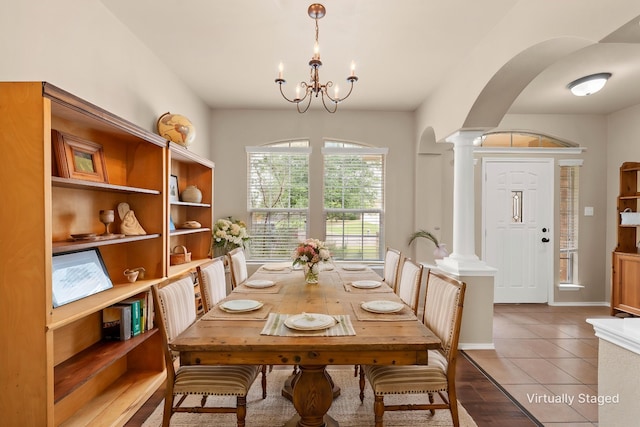 6728 Tierra Dr, Woodway, TX 76712 - dining room featuring arched walkways, tile patterned flooring, decorative columns, and a notable chandelier