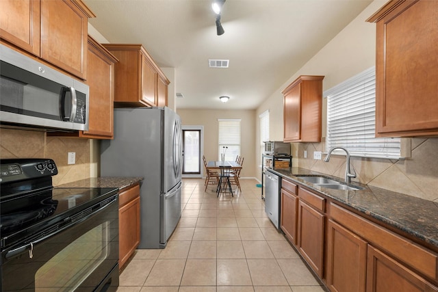 6728 Tierra Dr, Woodway, TX 76712 - kitchen with brown cabinetry, tasteful backsplash, a sink, light tile patterned floors, and stainless steel appliances