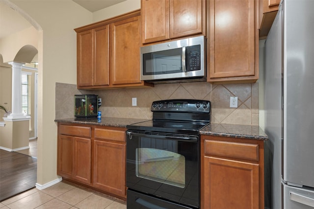 6728 Tierra Dr, Woodway, TX 76712 - kitchen featuring stainless steel appliances, arched walkways, ornate columns, and tasteful backsplash