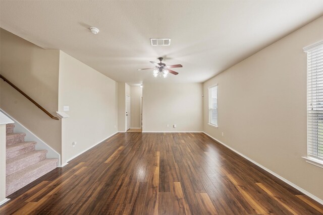 6728 Tierra Dr, Woodway, TX 76712 - unfurnished living room with dark wood-style flooring, ceiling fan, baseboards, visible vents, and stairway