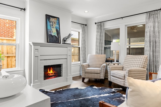 sitting room featuring recessed lighting, ornamental molding, wood finished floors, and a fireplace
