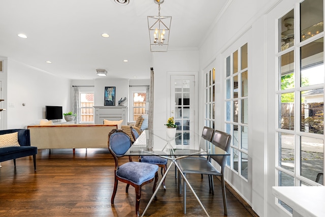 dining area with crown molding, recessed lighting, dark wood-type flooring, and a notable chandelier