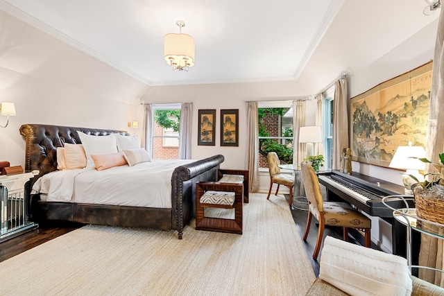 bedroom with ornamental molding and wood finished floors