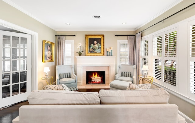 living area featuring visible vents, ornamental molding, a wealth of natural light, and a lit fireplace