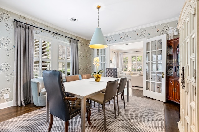 dining space with crown molding, wallpapered walls, dark wood-style floors, and visible vents