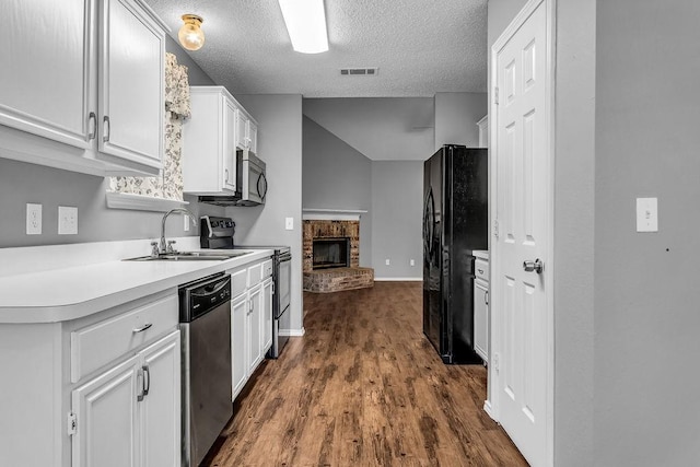 kitchen featuring stainless steel dishwasher, freestanding refrigerator, visible vents, white cabinetry, and electric stove