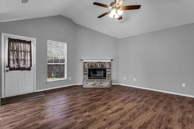 unfurnished living room with a ceiling fan, dark wood-style flooring, vaulted ceiling, and a fireplace