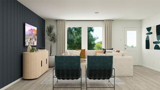 dining room featuring baseboards, light wood-style flooring, and an accent wall