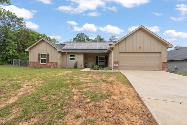 single story home featuring board and batten siding, driveway, solar panels, a front yard, and an attached garage