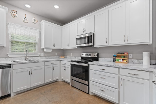 kitchen with finished concrete floors, a sink, stainless steel appliances, recessed lighting, and white cabinetry
