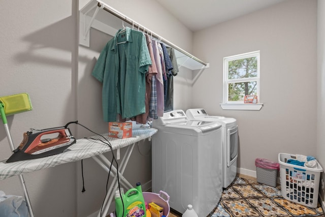 clothes washing area with washing machine and clothes dryer, laundry area, baseboards, and tile patterned floors
