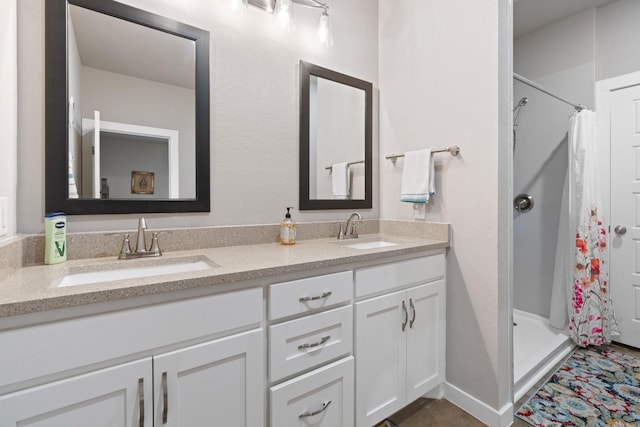 bathroom featuring double vanity, a sink, and a stall shower