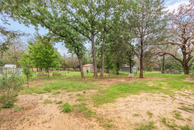 view of yard featuring fence, an outbuilding, and a storage shed