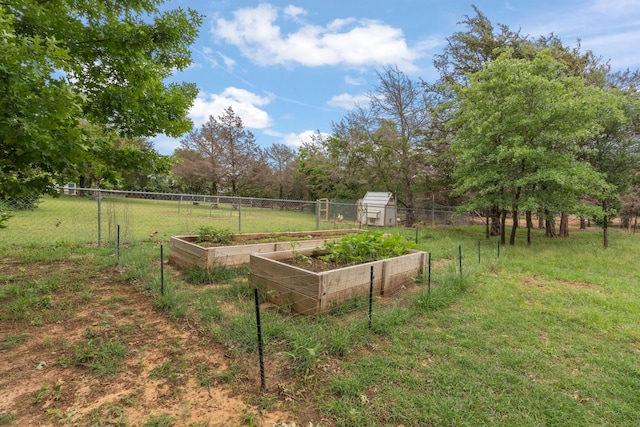 view of yard with fence, a garden, and an outbuilding