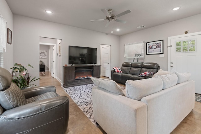 living area featuring visible vents, recessed lighting, a glass covered fireplace, and ceiling fan