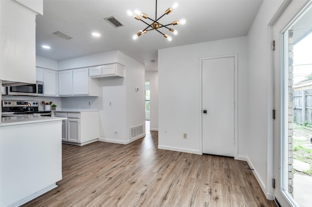 kitchen featuring stainless steel appliances, visible vents, a wealth of natural light, and a chandelier