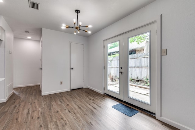 doorway featuring french doors, light wood-type flooring, and visible vents