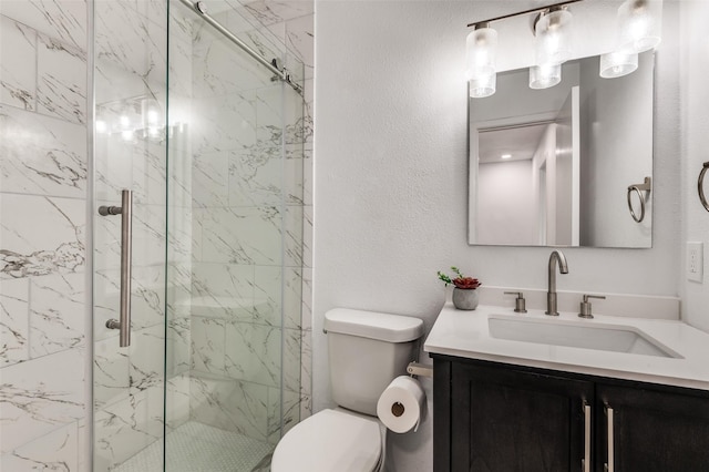 full bath featuring a marble finish shower, vanity, and toilet