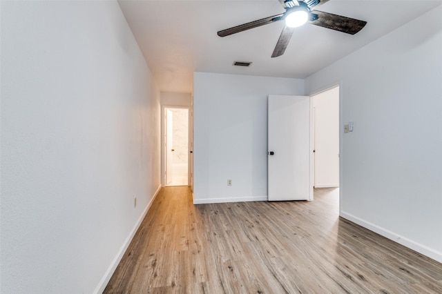 unfurnished bedroom with baseboards, ceiling fan, wood finished floors, and visible vents