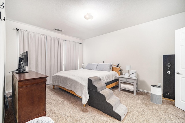 bedroom with visible vents and light carpet