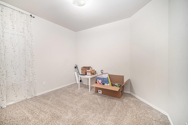 recreation room featuring baseboards and carpet