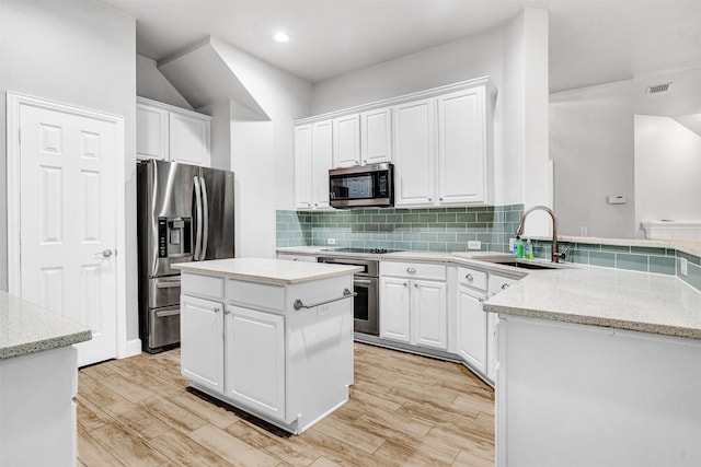kitchen with backsplash, visible vents, a sink, stainless steel appliances, and white cabinetry