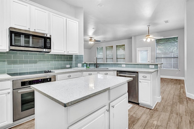 kitchen featuring a peninsula, ceiling fan, appliances with stainless steel finishes, and a sink