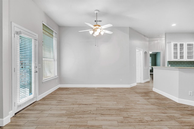unfurnished living room with light wood-type flooring, a ceiling fan, baseboards, and recessed lighting
