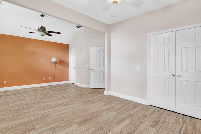 unfurnished room with ceiling fan, baseboards, lofted ceiling, and light wood-type flooring