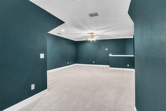 unfurnished room with baseboards, a ceiling fan, carpet flooring, and visible vents