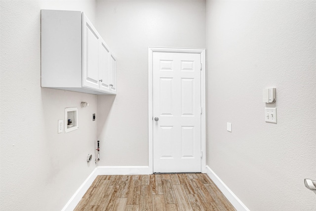 washroom featuring cabinet space, hookup for a washing machine, light wood-style flooring, hookup for a gas dryer, and baseboards